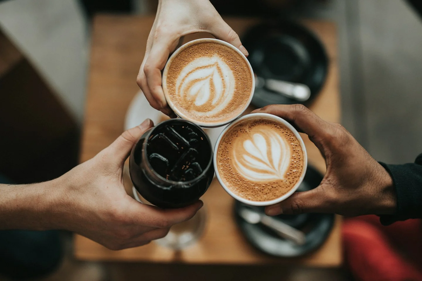 Coffee cups, beans, and a warm cafe tabletop
